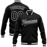 Black custom varsity jacket with white striped cuffs, personalized team name on the front, and custom name with number on the back.